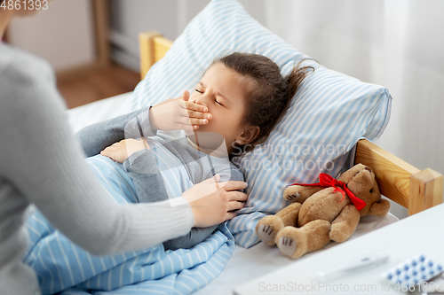 Image of mother and sick little daughter in bed at home