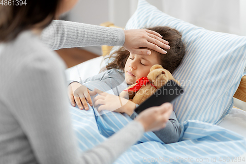 Image of sick daughter and mother with phone at home