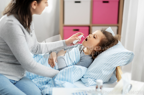 Image of mother with oral spray treats sick little daughter