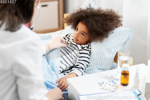 Image of doctor with stethoscope and sick girl in bed