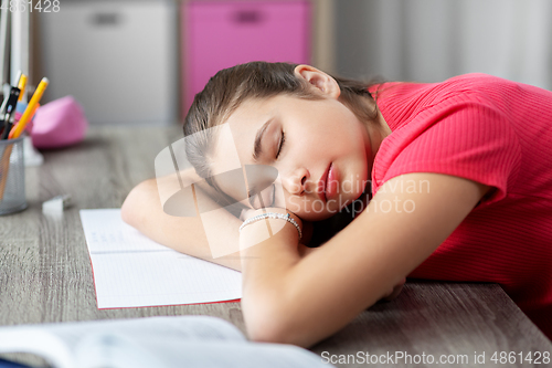 Image of tired student girl sleeping on table at home