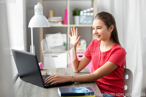 Image of student girl with laptop having video call at home