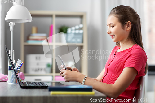 Image of girl with smartphone distracting from homework