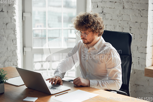 Image of Caucasian young man in business attire working in office, job, online studying