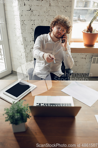 Image of Caucasian young man in business attire working in office, job, online studying