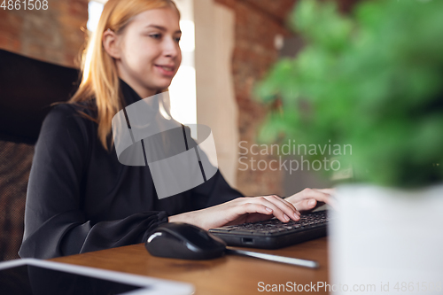 Image of Caucasian young woman in business attire working in office