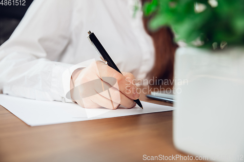 Image of Caucasian young woman in business attire working in office