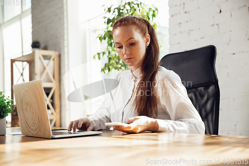 Image of Caucasian young woman in business attire working in office