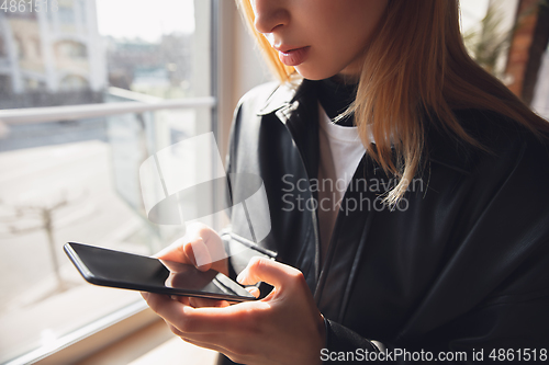 Image of Young woman using gadgets to watch cinema, photos, online courses, taking selfie or vlog, online shopping