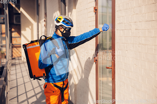 Image of Contacless delivery service during quarantine. Man delivers food and shopping bags during isolation