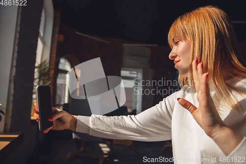 Image of Young woman using gadgets to watch cinema, photos, online courses, taking selfie or vlog, online shopping