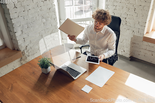 Image of Caucasian young man in business attire working in office, job, online studying