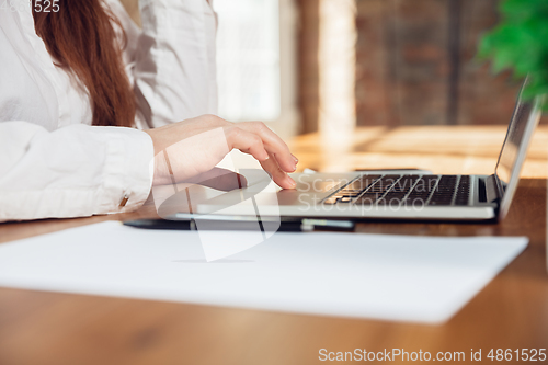 Image of Caucasian young woman in business attire working in office