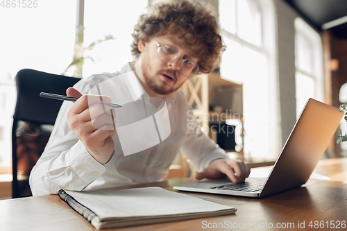 Image of Caucasian young man in business attire working in office, job, online studying