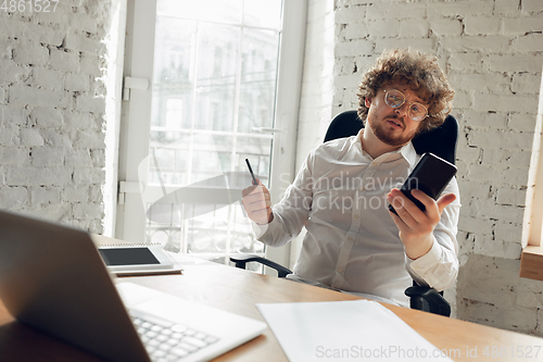 Image of Caucasian young man in business attire working in office, job, online studying