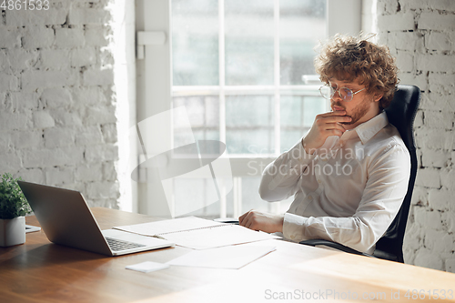 Image of Caucasian young man in business attire working in office, job, online studying