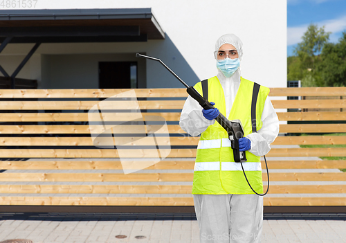 Image of sanitation worker in hazmat with pressure washer