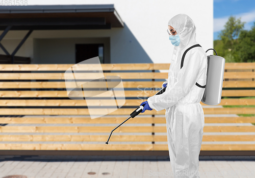 Image of sanitation worker in hazmat with pressure washer