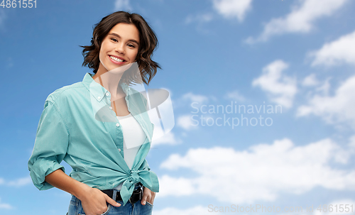 Image of portrait of smiling young woman in turquoise shirt