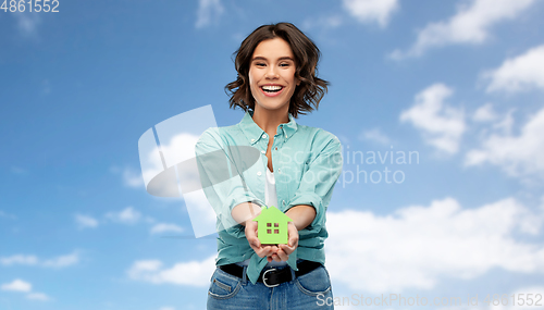 Image of smiling young woman holding green house