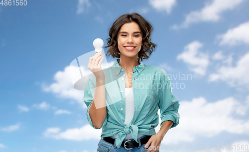 Image of smiling woman holding energy saving lighting bulb