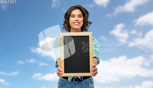 Image of portrait of smiling woman showing black chalkboard