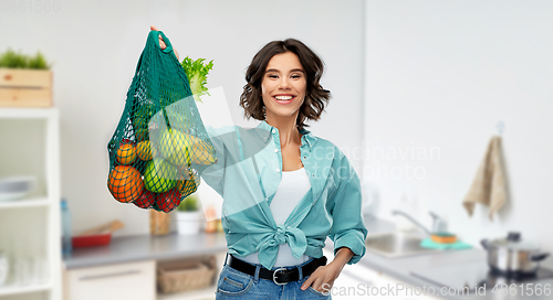 Image of happy smiling woman with food in reusable net bag