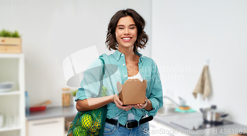 Image of happy woman with food in reusable net bag and wok