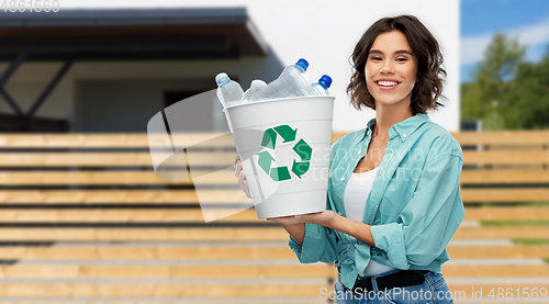 Image of smiling young woman sorting plastic waste