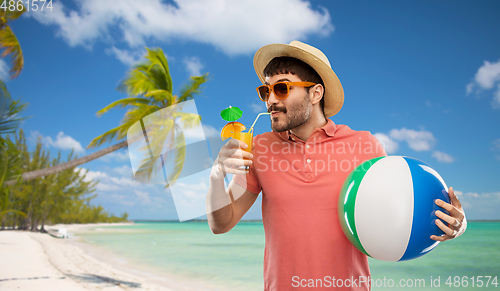 Image of happy man in straw hat with juice on beach