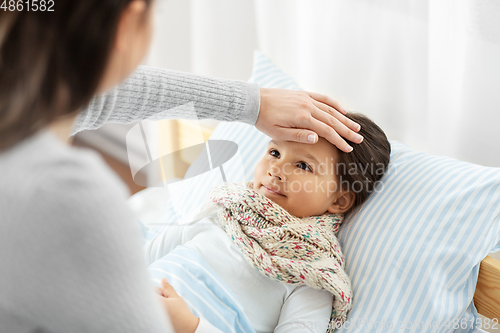 Image of mother measuring temperature of sick daughter