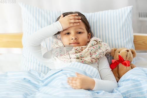 Image of sick little girl lying in bed at home