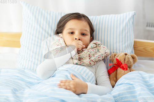 Image of sick coughing girl lying in bed at home