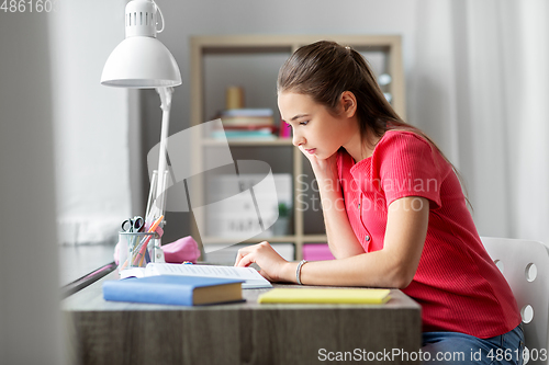 Image of student teenage girl reading book at home