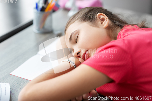 Image of tired student girl sleeping on table at home