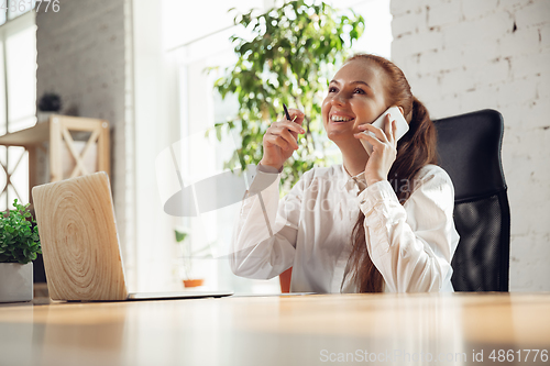 Image of Caucasian young woman in business attire working in office