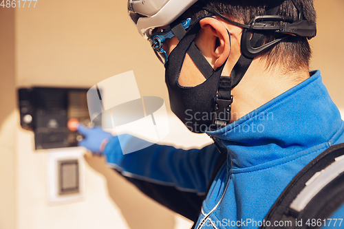 Image of Contacless delivery service during quarantine. Man delivers food and shopping bags during isolation