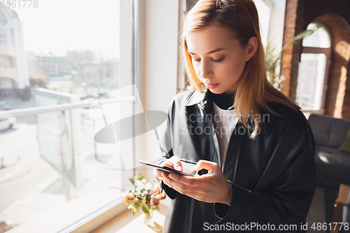 Image of Young woman using gadgets to watch cinema, photos, online courses, taking selfie or vlog, online shopping