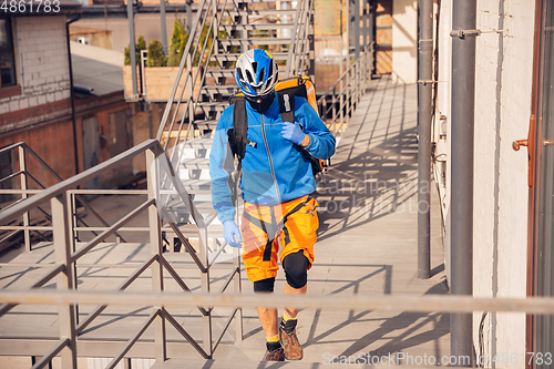 Image of Contacless delivery service during quarantine. Man delivers food and shopping bags during isolation