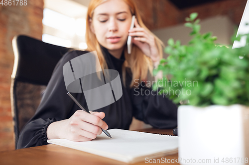 Image of Caucasian young woman in business attire working in office