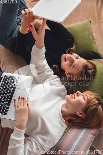 Image of Young friends, women using gadgets to watch cinema, photos, online courses, taking selfie or vlog, top view