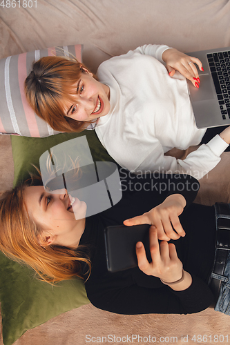 Image of Young friends, women using gadgets to watch cinema, photos, online courses, taking selfie or vlog, top view