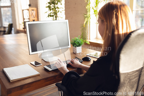 Image of Caucasian young woman in business attire working in office