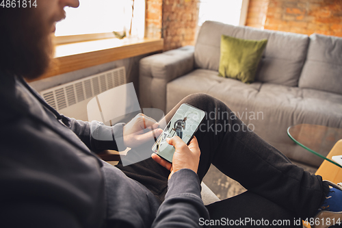 Image of Young man using gadgets to watch cinema, photos, online courses, taking selfie or vlog, online shopping