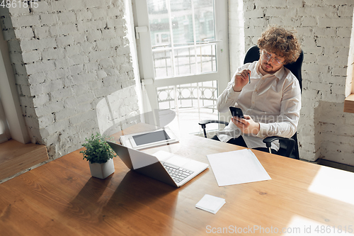 Image of Caucasian young man in business attire working in office, job, online studying