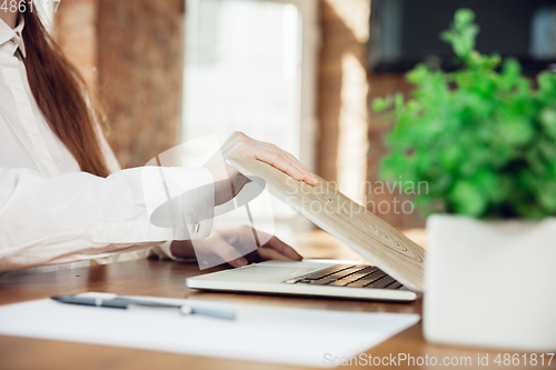 Image of Caucasian young woman in business attire working in office