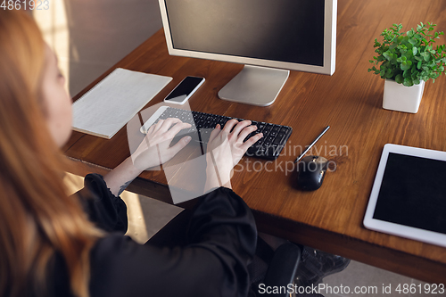 Image of Caucasian young woman in business attire working in office