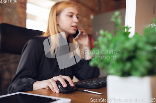 Image of Caucasian young woman in business attire working in office