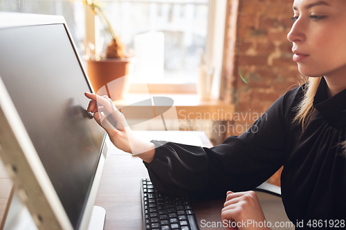 Image of Caucasian young woman in business attire working in office