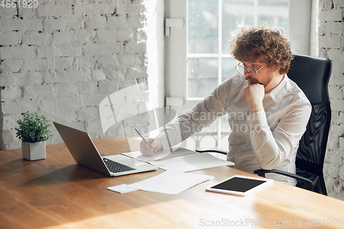 Image of Caucasian young man in business attire working in office, job, online studying